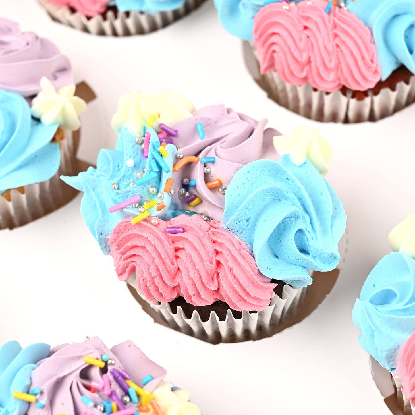 Close-up of blue, pink and purple buttercream cupcakes in the birthday gift bundle
