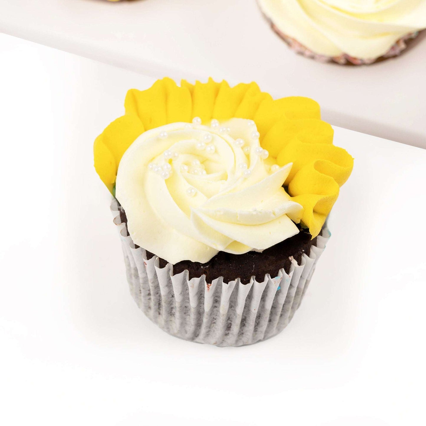 Close-up of a yellow and white buttercream cupcake from the recovery gift bundle