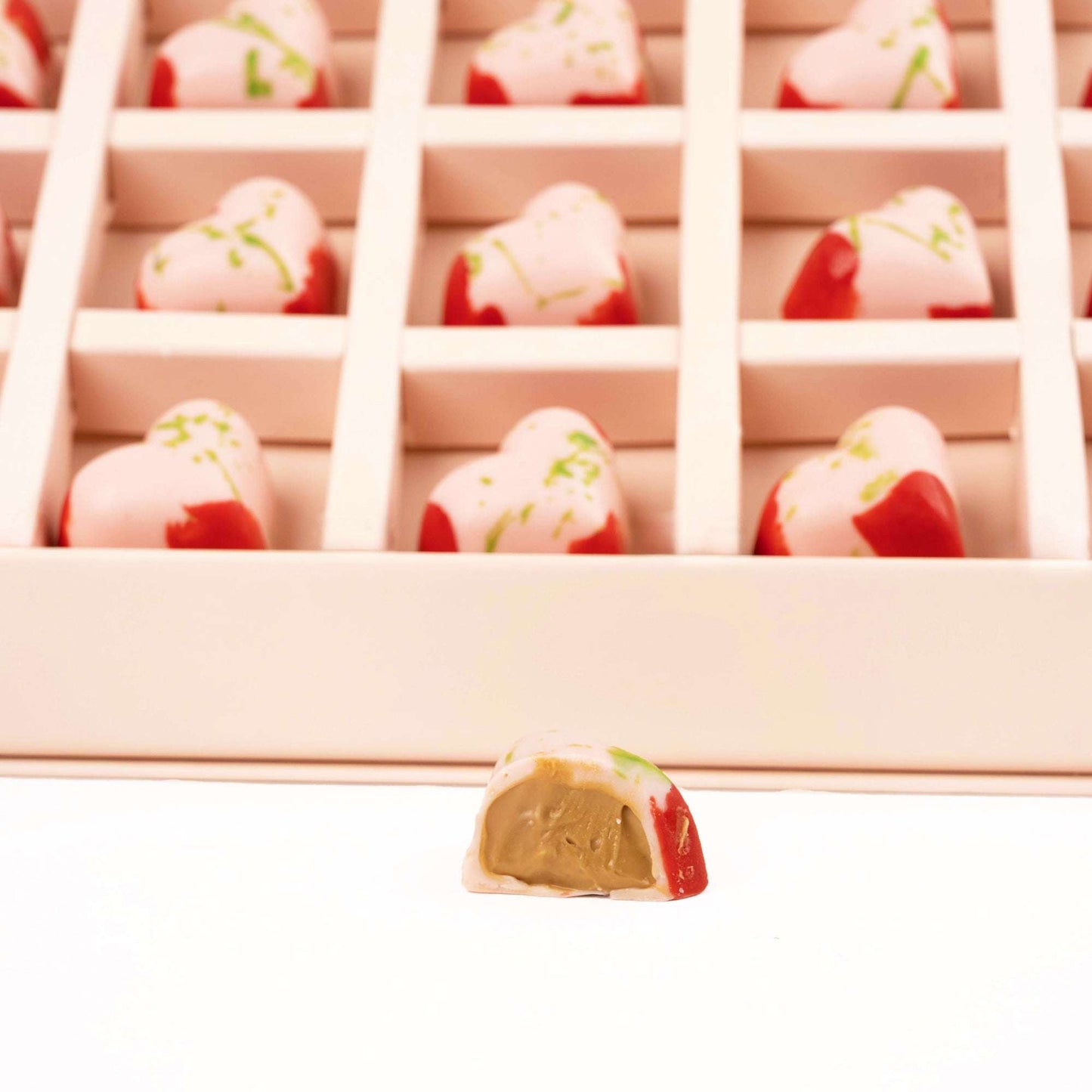 Close-up of strawberry-style chocolates, including one cut open to show the filling