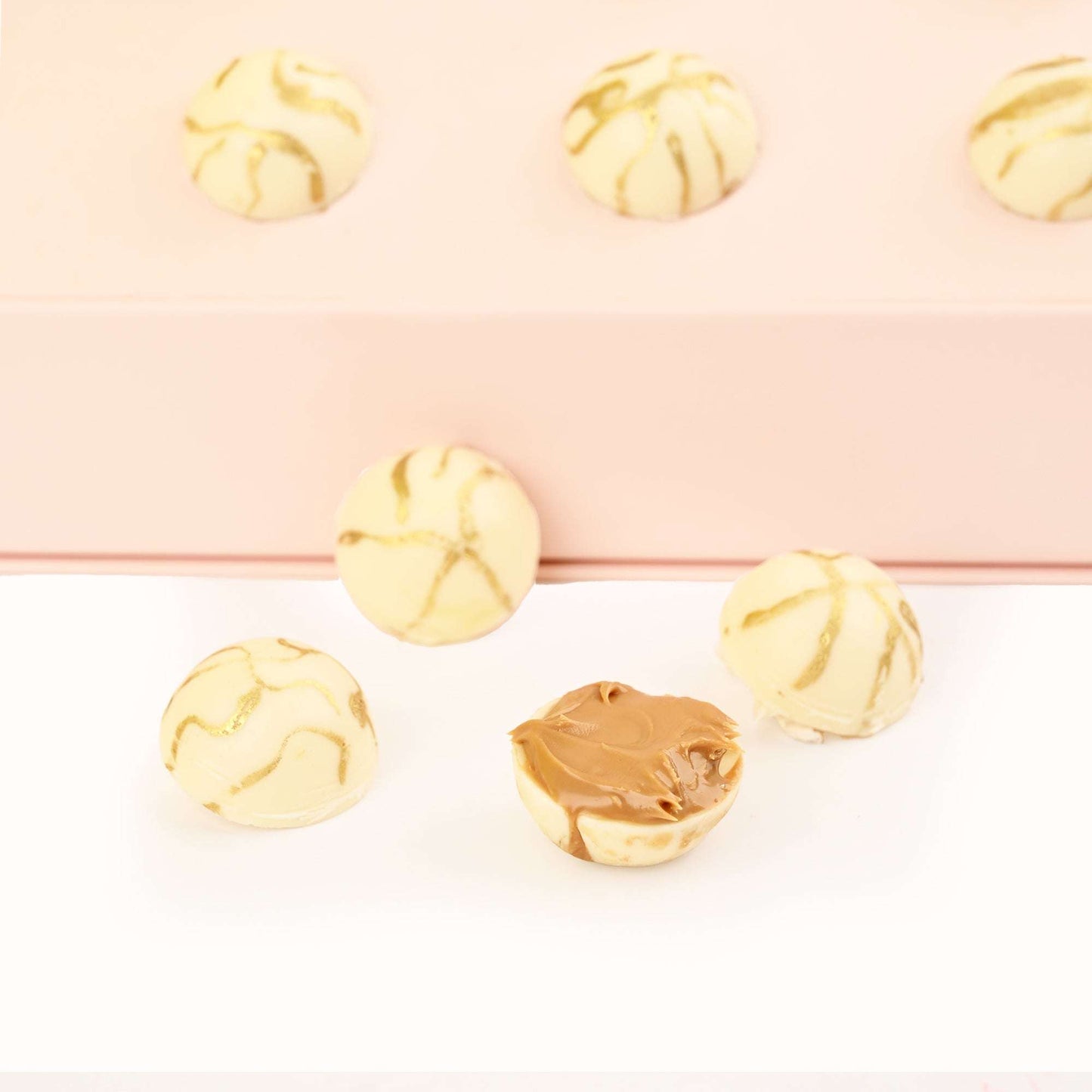 Close-up of white and gold decorated chocolates from the thank you gift